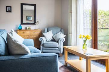 The sitting-area has French doors that open out onto a fully enclosed private patio at the side of the cottage.
