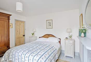 A comfy king-size bed awaits, in this country styed bedroom.