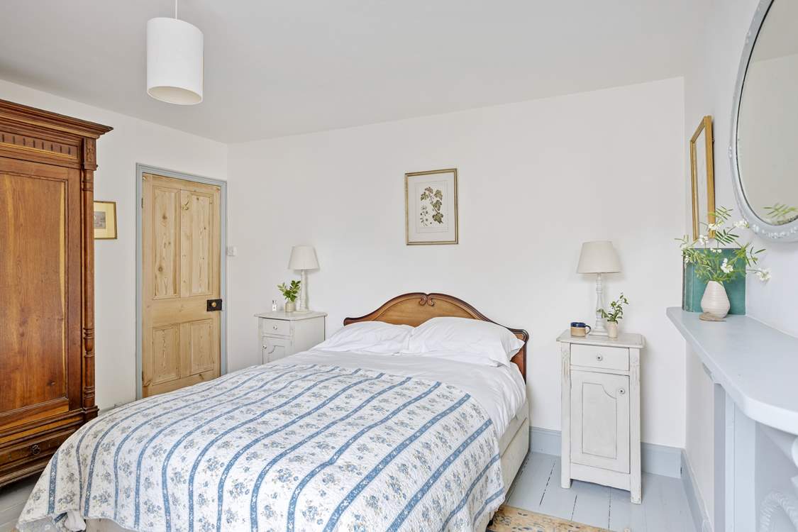 A comfy king-size bed awaits, in this country styed bedroom.