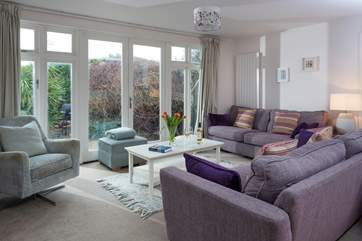 Large, comfortable sofas overlook the garden and patio-area.