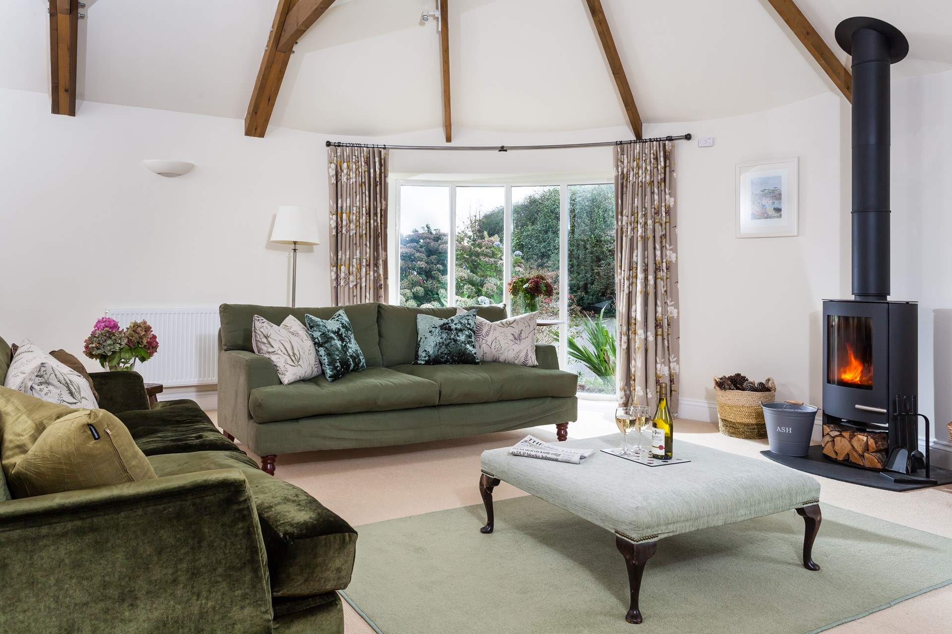 The living-room is spacious and light due to the large windows and high ceiling.