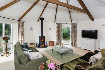 The living-room is spacious and light due to the large windows and high ceiling.