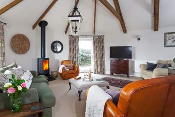 The sitting-room is spacious and light due to the large windows and high ceiling.
