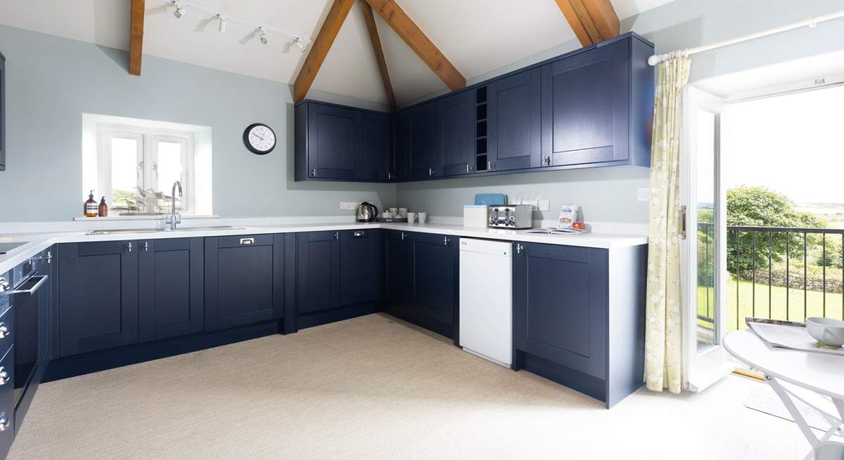 The large kitchen has the most amazing views over the countryside and doors that open to a small balcony and steps down to the garden. 