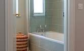 The family bathroom with beautifully tiled bath and fitted shower. - Thumbnail Image