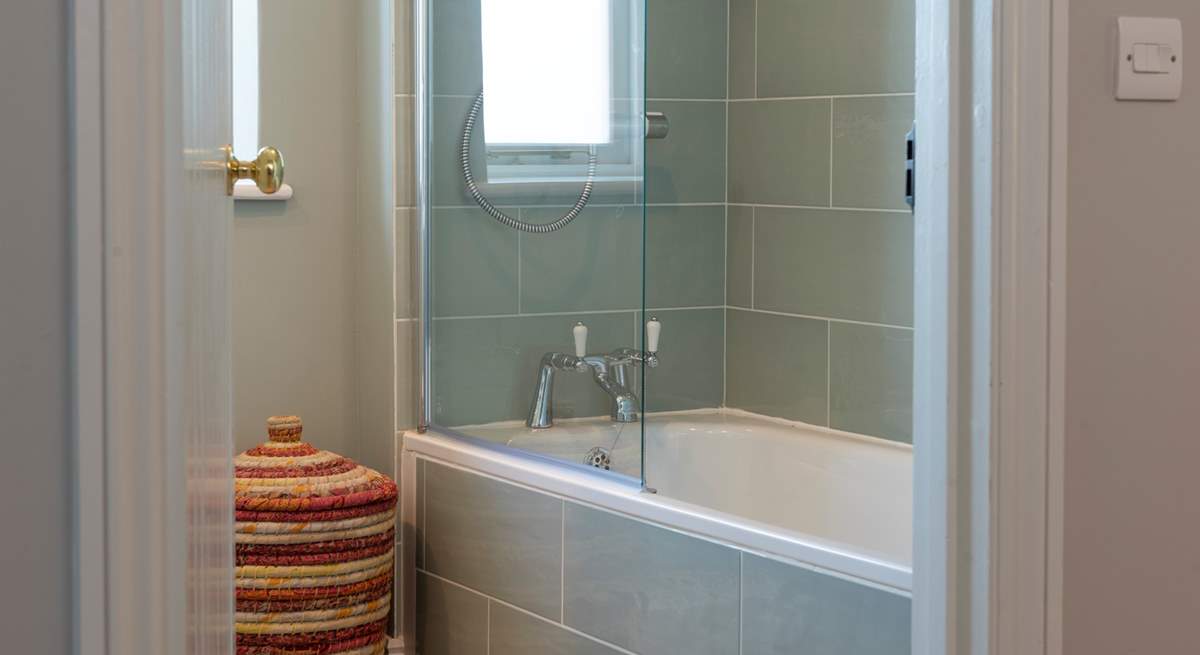 The family bathroom with beautifully tiled bath and fitted shower.