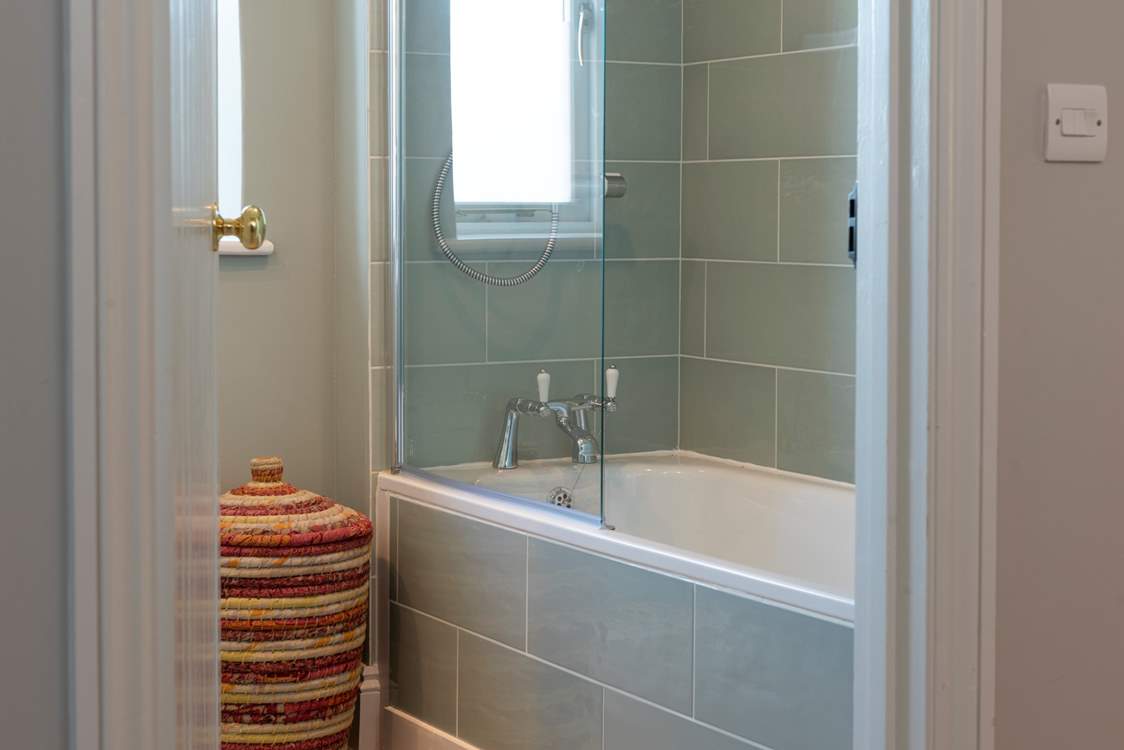 The family bathroom with beautifully tiled bath and fitted shower.
