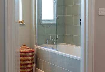 The family bathroom with beautifully tiled bath and fitted shower.