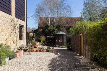 This view is from the front door looking back up the path with the summer-house in front of you and the garden around the side of the fencing to the right.
