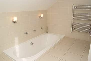 The bathroom has a sunken bath.
