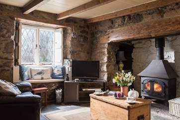 The sitting-room has a cosy wood-burner in the inglenook fireplace and comfy sofas.