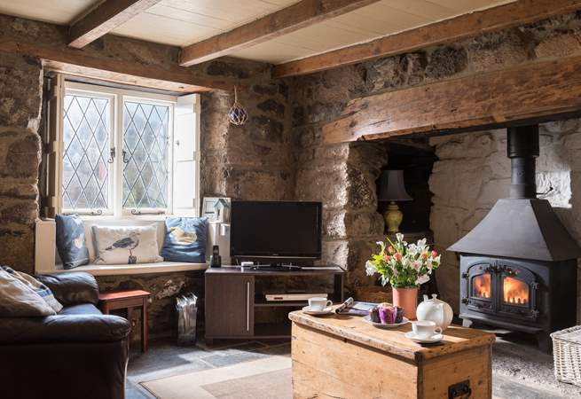 The sitting-room has a cosy wood-burner in the inglenook fireplace and comfy sofas.