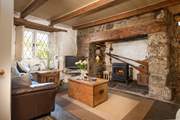 Room to relax with friends and family in the cottage sitting-room, with a cosy wood-burner effect electric stove.