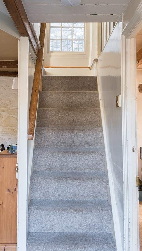 The cottage stairs lead to the family bathroom and three bedrooms.