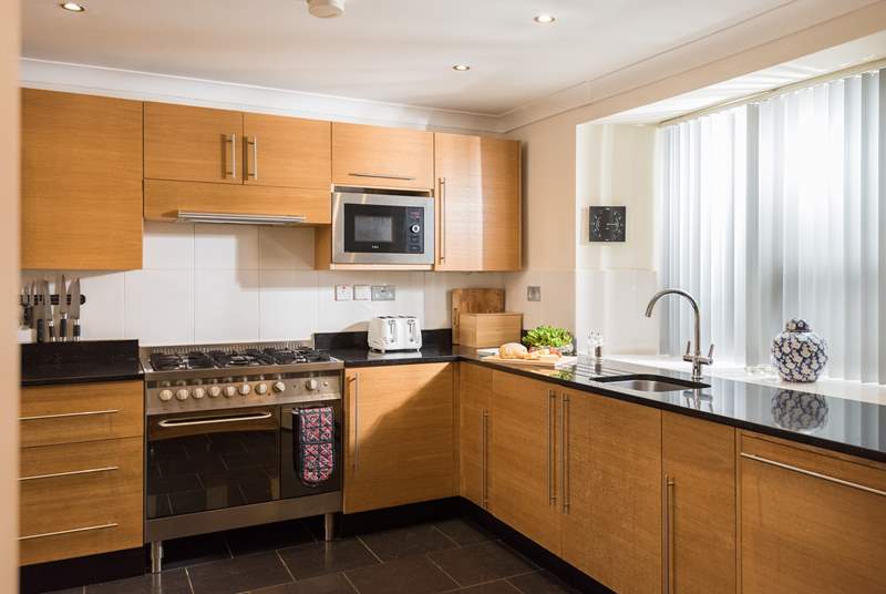 Granite work surfaces and solid wood units show the quality of the apartment.