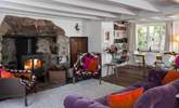 The main sitting-room with a roaring fire and dining-area. - Thumbnail Image