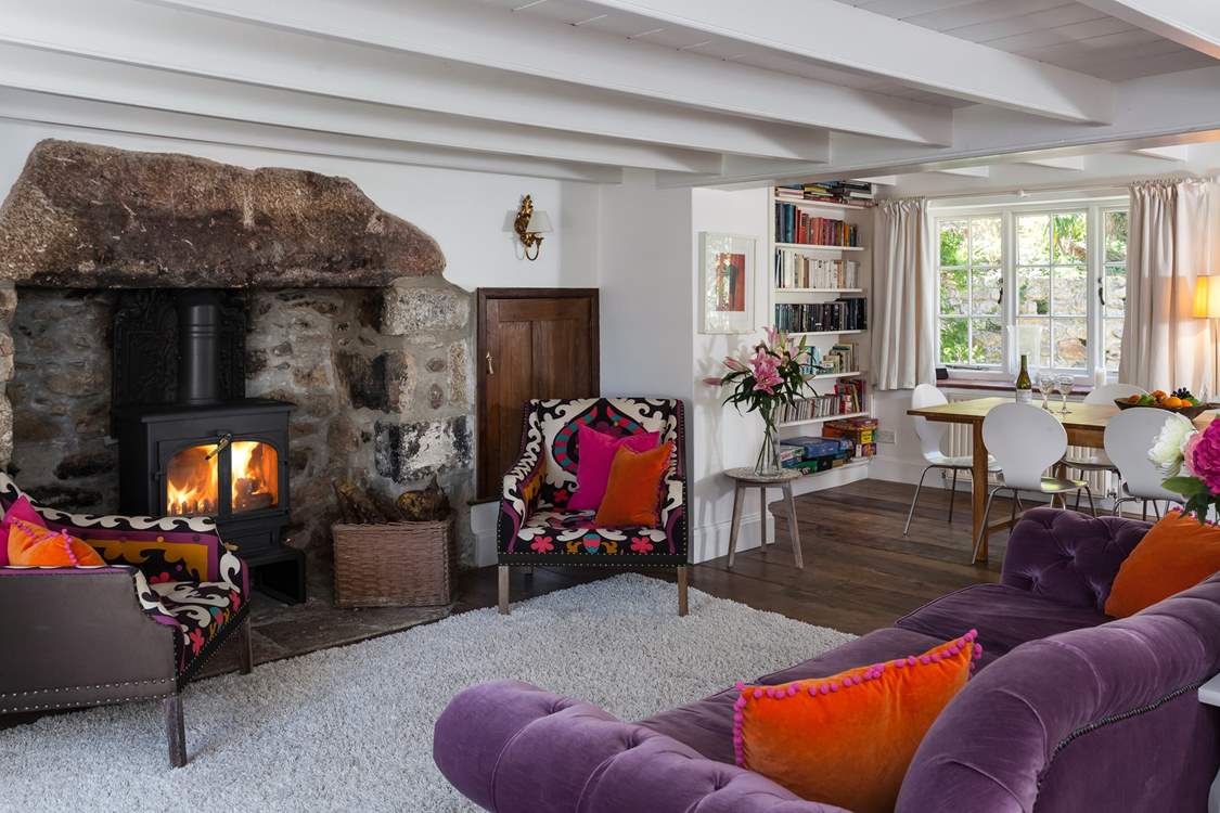 The main sitting-room with a roaring fire and dining-area.