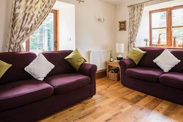 The sitting-room has comfy sofas, ideal for relaxing after a day of exploring.