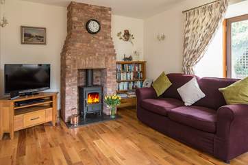 The dual-aspect sitting/dining-room has doors out to the garden and a wonderful wood-burner for cosy evenings in. There are two sofas to snuggle up on.