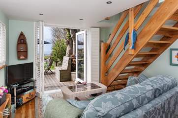 The lovely open plan living-room, has french doors which lead out onto the sunny decked-area.