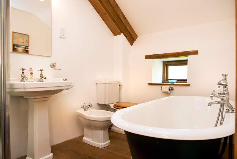 The en suite bathroom has a double-ended roll-top bath with a separate shower cubicle.
