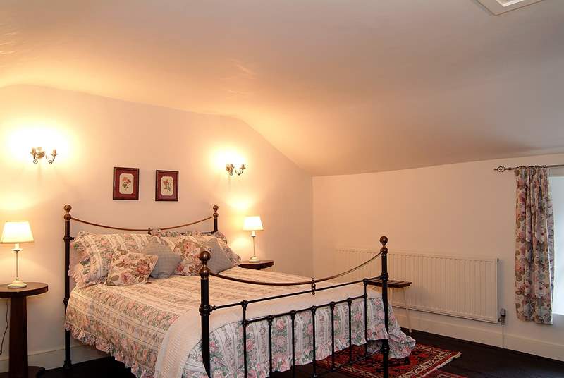 The spacious main bedroom has a 5' bed and plenty of space for a cot.