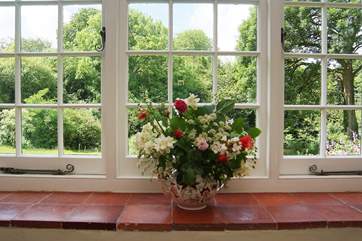 The sitting-room looks out over lawns and mature trees.