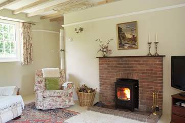 Comfortable armchairs flank the wood-burner.