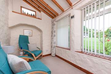 There are two steps leading up to the little sun-room which overlooks part of the owners' very attractive garden.