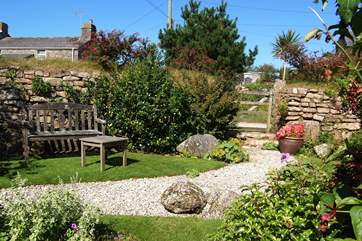 The pretty enclosed back garden with its manicured lawn and attractive flowerbeds.