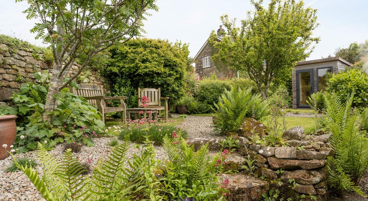 The pretty enclosed back garden with its manicured lawn and attractive flowerbeds.