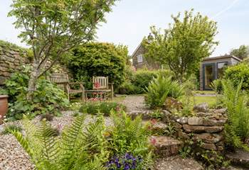 The pretty enclosed back garden with its manicured lawn and attractive flowerbeds.