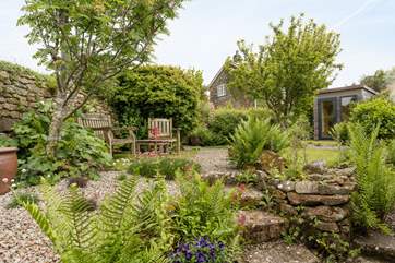 The pretty enclosed back garden with its manicured lawn and attractive flowerbeds.