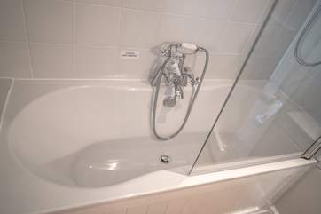 The bathroom offers a bath and an shower.