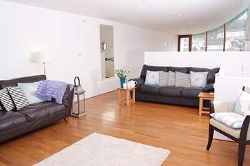 The open plan living space is divided by the kitchen-area, with the dining-table at the far end.