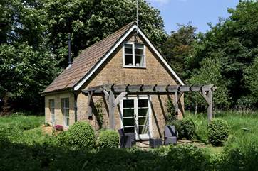 This is the meadow-side of The Pump House. There is a terrace beneath the pergola and not a house in sight.
