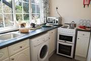 The cute kitchen has views over the beautifully maintained garden.