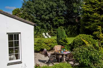 The mature gardens surround this pretty, private patio.