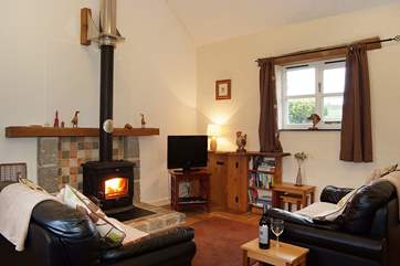 Two leather sofas face the welcoming wood-burner.