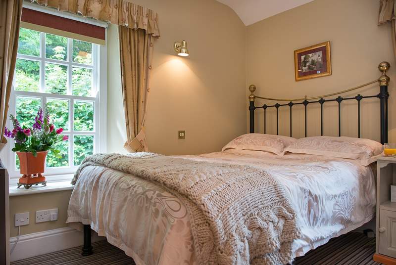 The bedroom has lovely linens and a gorgeous bedstead.