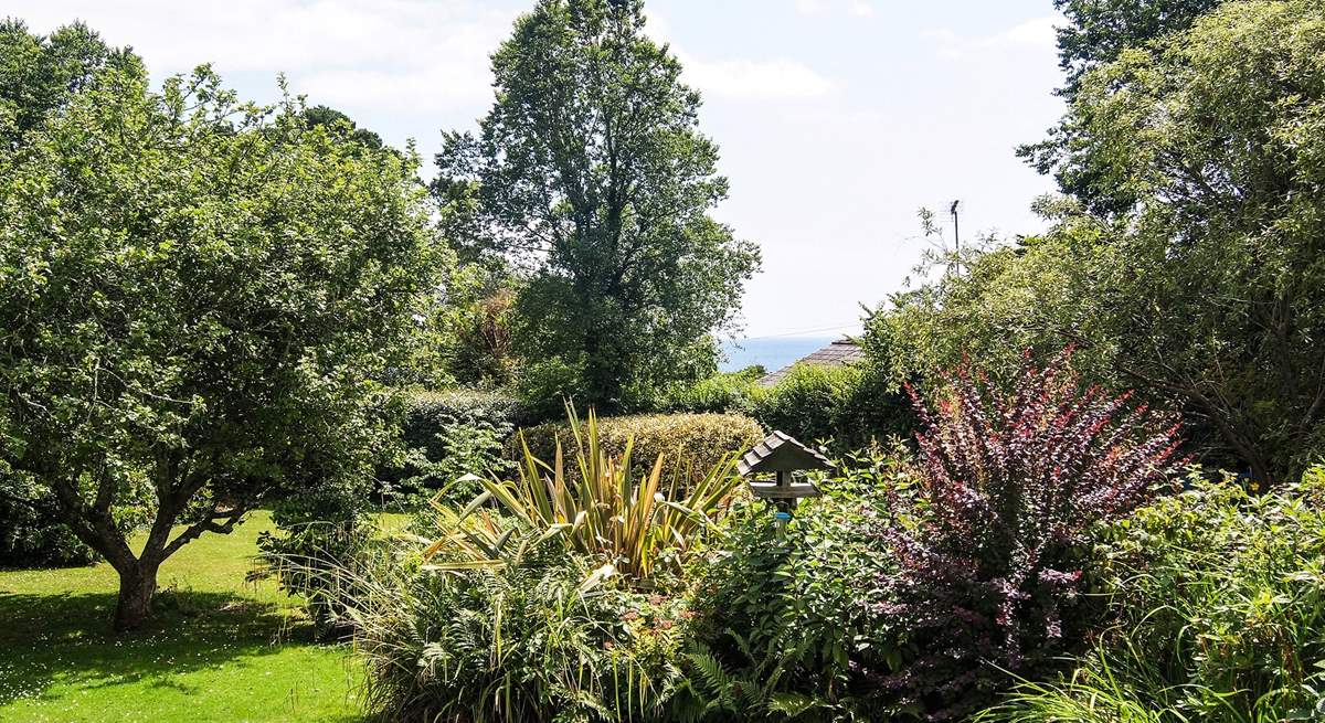 You can see the sea between the trees from the garden.