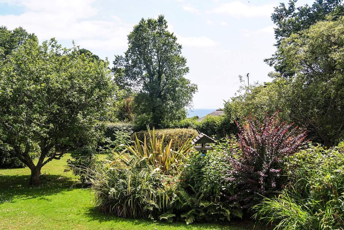 You can see the sea between the trees from the garden.