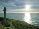 The Celtic cross on the clifftop at sunset.