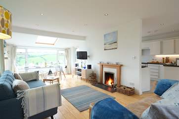 The open plan living-room is flooded with light from the large picture windows.