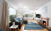 The open plan living-room is flooded with light from the large picture windows. - Thumbnail Image