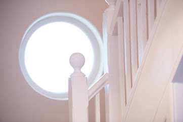 A porthole on the staircase looks out over the garden.