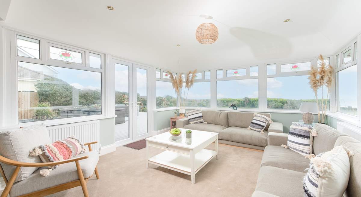 The sunny conservatory end of the sitting-room with double doors leading out to the decking and garden.