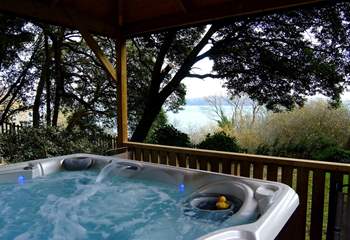 The hot tub looks out to the water.
