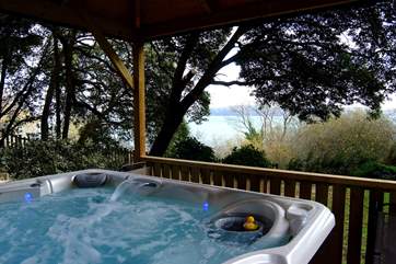 The hot tub looks out to the water.