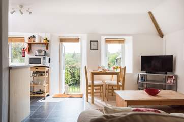 The kitchen, dining and sitting areas, with a door leading outside to the garden.